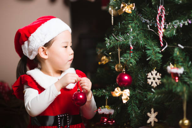 istock young girl decorating Christmas tree at home 1286215062