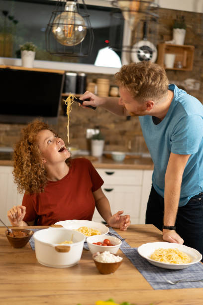 istock Playful couple having dinner together in the kitchen. 1286215104