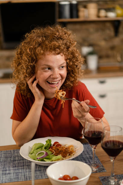 istock Happy young woman eating pasta. 1286215969