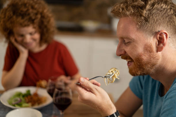 istock Happy young man eating dinner with girlfriend. 1286215982