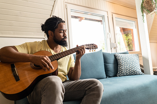 Man playing a guitar at home.