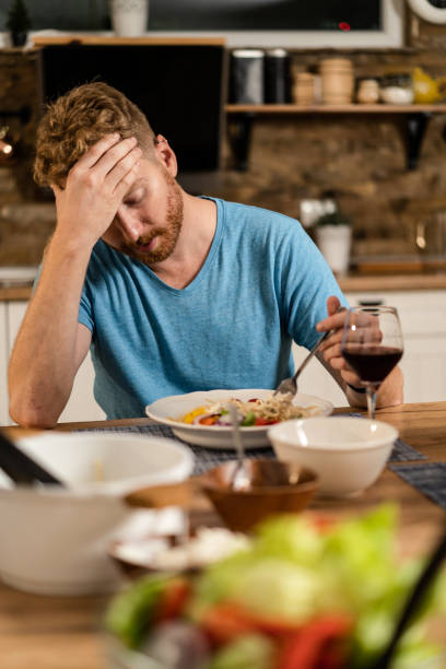 Depressed young man having no appetite to eat. Distraught young man  having no appetite to eat. eating disorder stock pictures, royalty-free photos & images