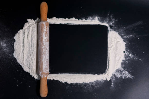 istock Rolling pin and white flour on a dark background. Free space for text. 1286217158