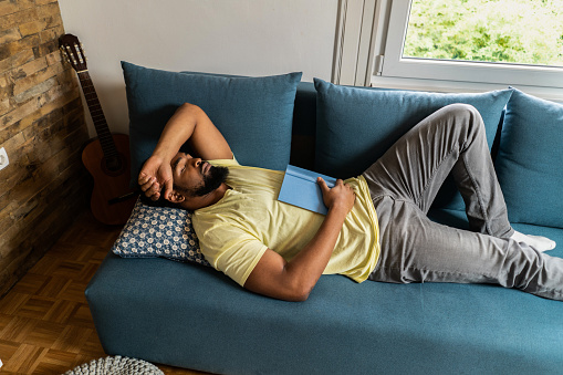 Hombre afroamericano tomando una siesta en casa. photo