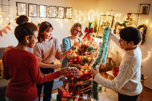 istock Young friends at home during Christmas and New Year's Day decorating Christmas tree 1286217543