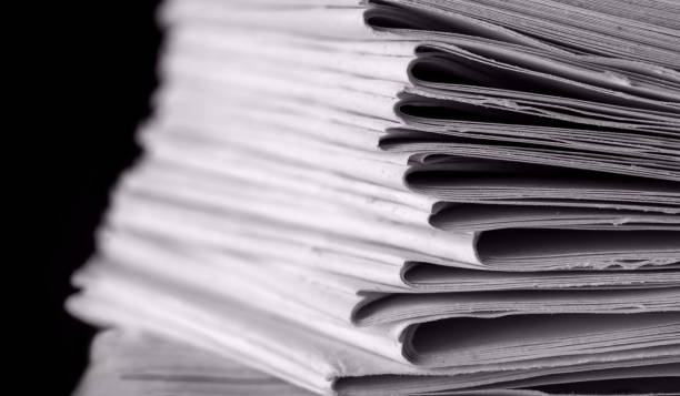 istock pile of paper documents in the office on black background 1286219854
