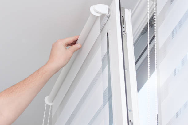 Man hands installing window roller duo system day and night. Man hands installing window roller duo system day and night. retractable photos stock pictures, royalty-free photos & images