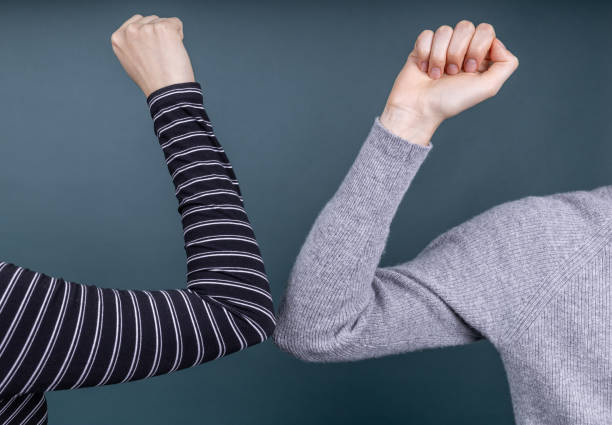 two people greeting each other with elbows