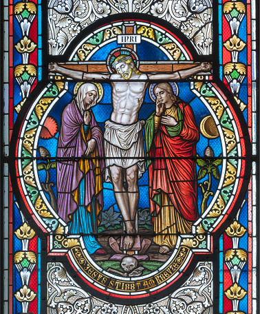 Vienna - The Crucifixion on the stained glass in  in church Pfarrkirche Kaisermühlen by workroom Tiroler Glasmalerei-Anstalt from end of 19. cent..