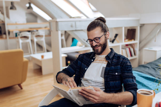 istock Young man enjoying reading at home 1286224359