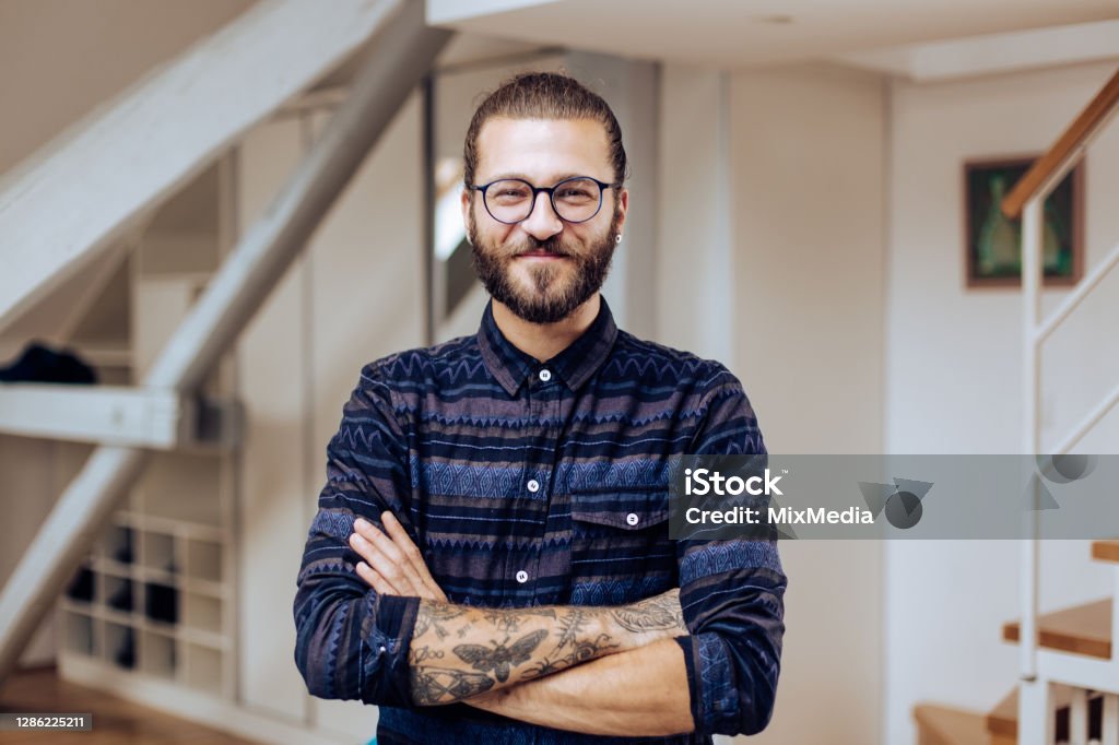 Portrait of a handsome young man posing at home Portrait of a handsome young man posing indoors. Hipster Culture Stock Photo