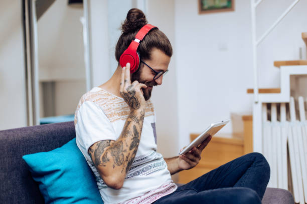 istock Young man playing music on tablet and enjoying 1286225270