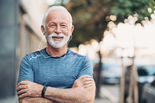 Portrait of a smiling senior athlete outside in the city