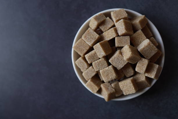Istanbul, Turkey-November 17, 2020: Brown Sugar in White Plate On Dark Gray Concrete Background, Studio Shot, Flat Lay, Full Frame, Istanbul, Turkey.
