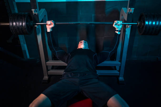 istock Man lying on the bench, lifting weights in the gym 1286229741