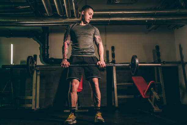 istock Man using the barbell at gym 1286230693