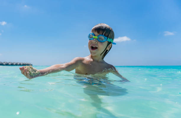 istock Boy with swimming goggles in the sea 1286232771