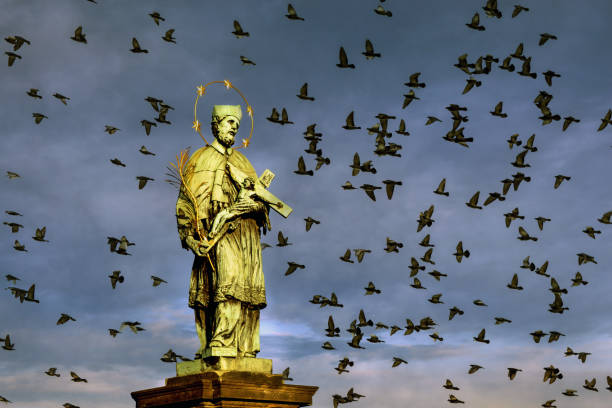 A beautifully detailed statue of a mother holding her child stands prominently in Prague, surrounded by historic buildings and a clear blue sky, showcasing the city's rich culture.