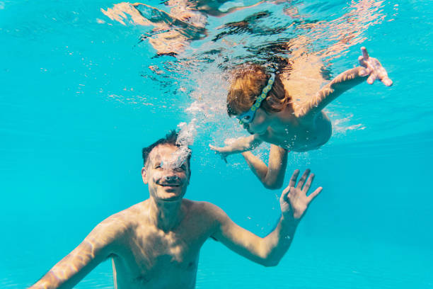 istock Boy with father swimming underwater 1286233496