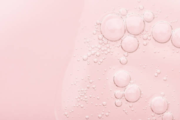 The texture of a liquid transparent gel for face cleansing. Sample of oil serum with bubbles on a pink background. Moisturizing cosmetic beauty product for skincare. Lotion for dry skin care The texture of a liquid transparent gel for face cleansing. Sample of oil serum with bubbles on a pink background. Moisturizing cosmetic beauty product for skincare. Lotion for dry skin care. shower gel photos stock pictures, royalty-free photos & images