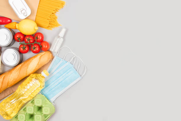 istock Flat lay composition with food and medicines donations on grey background with copyspace - pasta, fresh vegatables, canned food, baguette, cooking oil. Food donations and food bank concept 1286240798