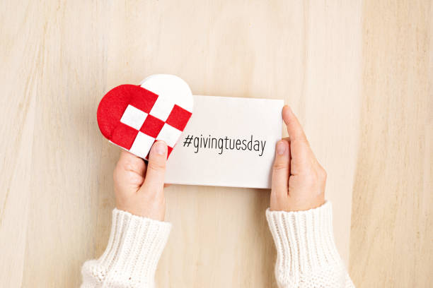 Giving Tuesday concept with woman hands holding red and white heart, charity day concept Giving Tuesday concept with woman hands holding red and white heart, charity day concept. Donation, philantropy, help and support idea.  Top view, flat lay giving tuesday stock pictures, royalty-free photos & images