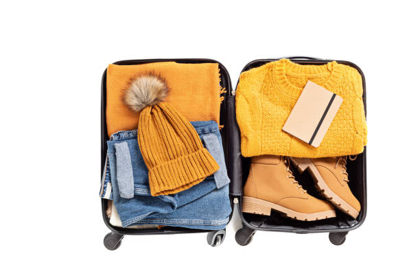 pose plate avec la valise ouverte avec des vêtements occasionnels pour l’automne, vacances d’hiver sur le fond blanc - ski pants photos et images de collection