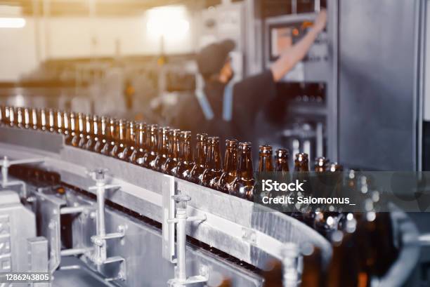 Glass Beer Bottles Of Brown Color On The Conveyor Line Of Beer Bottling Close Up Stock Photo - Download Image Now