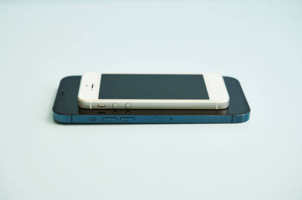 brandneues iphone 12 pro max in pacific blue und iphone 5 in studio-einstellung - iphone 5 stock-fotos und bilder