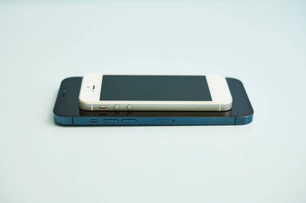 nuevo iphone 12 pro max en pacific blue y un iphone 5 en studio setting - iphone 5 fotografías e imágenes de stock