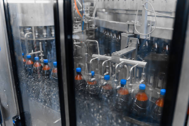 istock Automatic bottle washer on the beer filling line. Bottle washing process after capping 1286245779