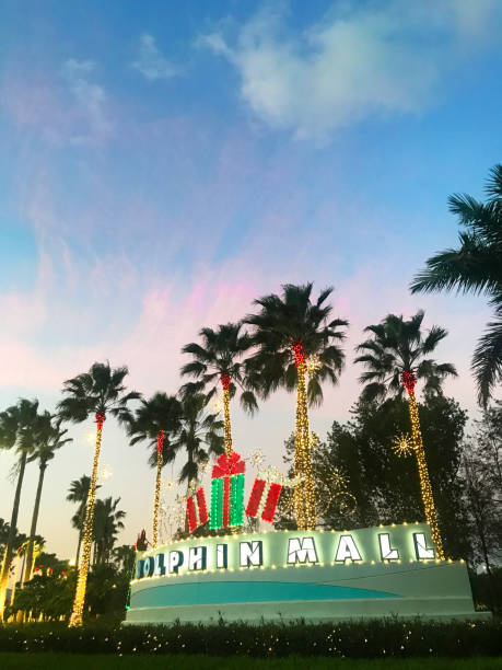 Dolphin Mall Shopping Entrance at sunset, Miami, Florida, USA Miami, Florida, United States - November 17, 2020: General landscape view of Dolphin Mall Shopping Center sign entrance from Northwest 12th Street in Miami, during the second wave of Covid-19 Corona Virus Quarantine in a sunny winter sunset afternoon. The Shopping Mall is located at 11401 NW 12th St, in Sweetwater, Miami-Dade County. The entrance is decorated with Christmas Lights and ornaments welcoming the most higher season of the year for sales.

The shopping is the biggest outlet in Miami Area, has 240 retails, the most famous brands around the world as: Adidas, Nike, Calvin Klein, Victory Secrets and much more, divided into three districts: Playa (Beach), Ramblas (Boulevards), and Moda (Fashion), and has nine zones. kendall stock pictures, royalty-free photos & images