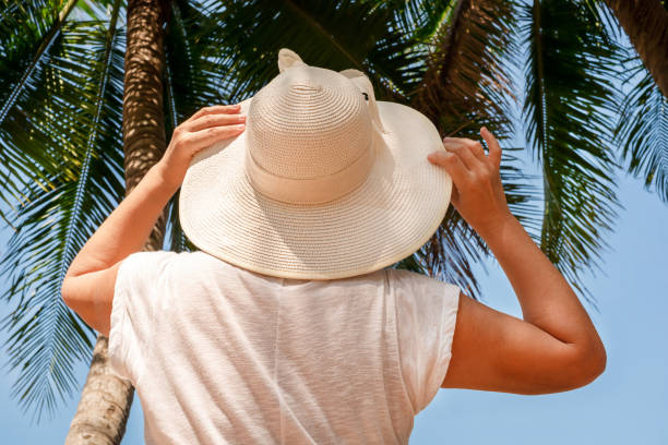 istock woman in hat looking at palm trees 1286248262