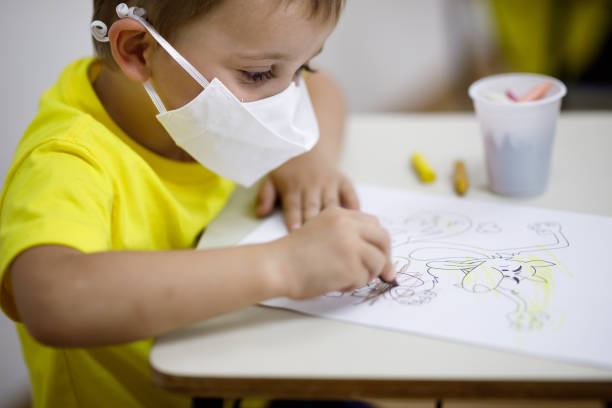 istock kid wearing protective face mask painting a drawing 1286249888