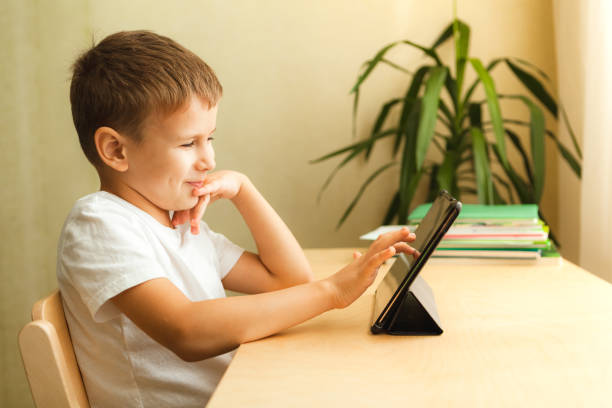 istock Happy child drawing on tablet sitting by desk 1286254710