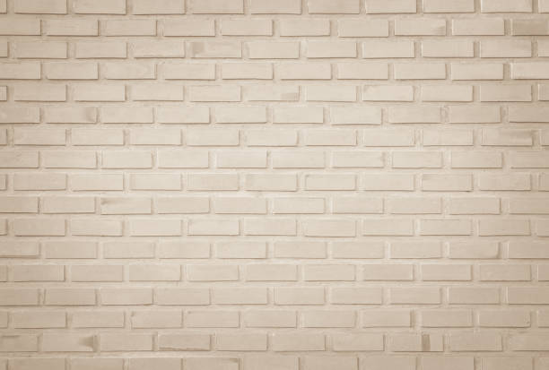 istock Empty Background of wide cream brick wall texture. Old brown brick wall concrete or stone pattern nature, wallpaper limestone abstract floor/Grid uneven interior rock. Home & office design backdrop. 1286255514