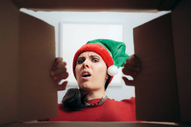 besviken julkvinna tittar inuti kartong presentförpackning - santa hat bildbanksfoton och bilder