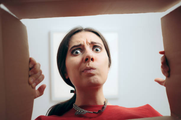 mujer decepcionada mirando dentro de la caja de regalo de cartón - devolución del saque fotografías e imágenes de stock