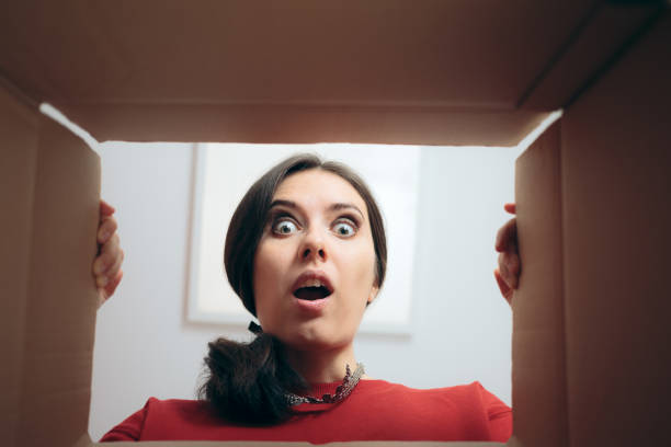 istock Funny Woman Looking Inside Cardboard Gift Box 1286258767