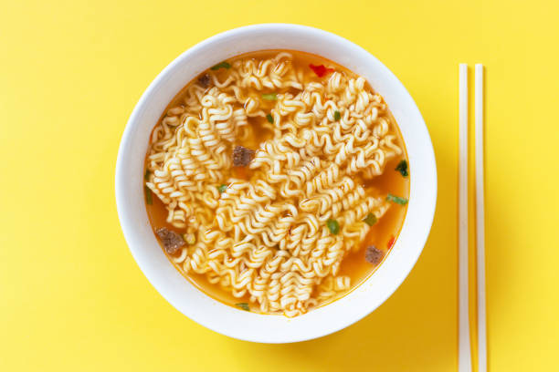 soupe instantanée de nouilles dans un bol blanc sur la vue supérieure de fond jaune. - nouilles photos et images de collection