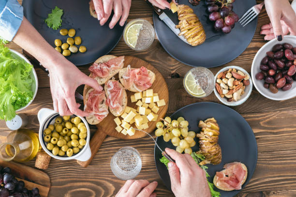 istock Top view of three people having dinner together on rustic wooden table Friends having dinner concept 1286261515