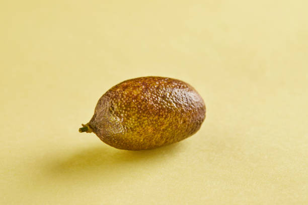 istock Ripe fresh mini lemon on a yellow background with shadow 1286266101