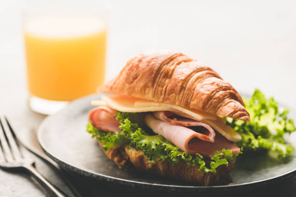 istock Croissant sandwich with ham, cheese and lettuce salad 1286268198