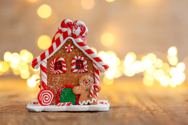 istock Gingerbread house under a Christmas tree with defocused lights. 1286269085