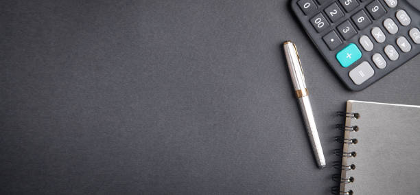 istock Pen, notepad and calculator on black background. 1286272225