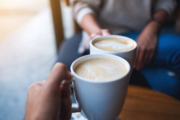 istock man and woman clinking white coffee mugs in cafe 1286276377