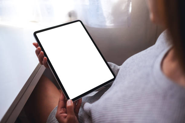 istock a woman holding digital tablet with blank white desktop screen 1286276381