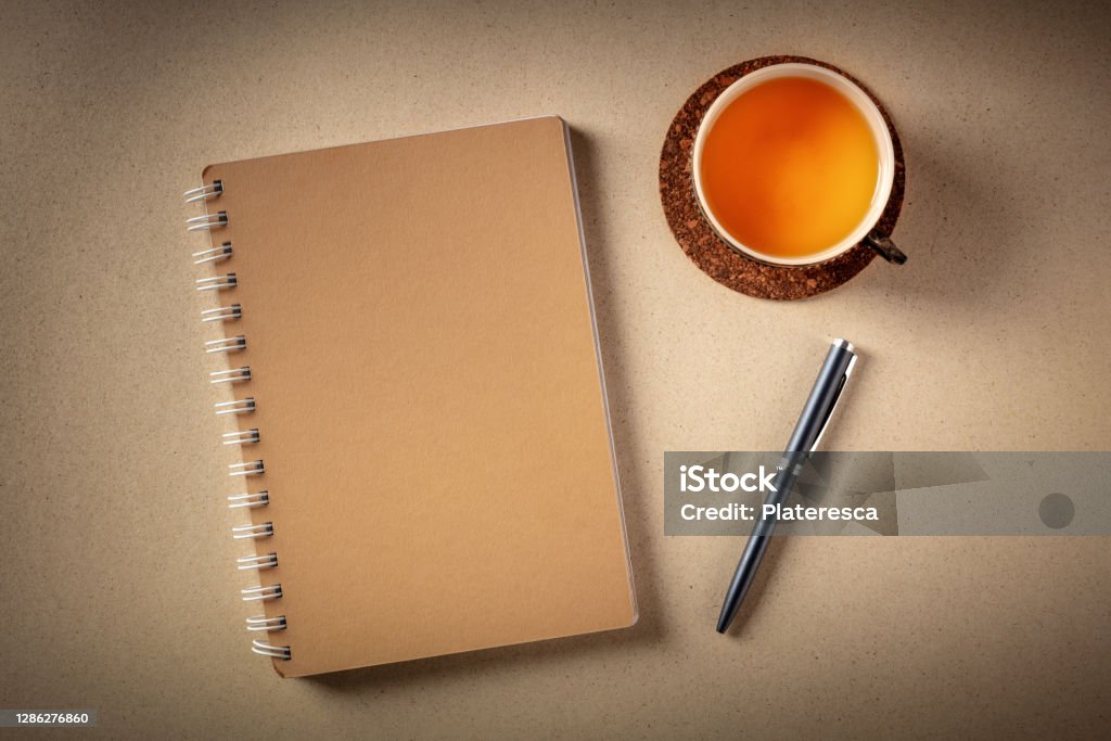 A diary on a desk, shot from above with a pen and a cup of tea A diary on a desk, shot from above with a pen and a cup of tea on a rustic background Bullet Journal Stock Photo