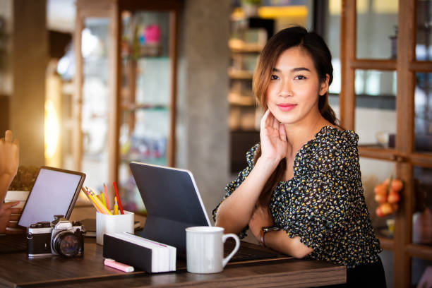 istock Two beautiful asian women Sitting at work online or studying during the coronavirus with a tablet in the morning, the sun warms happily. 1286280935