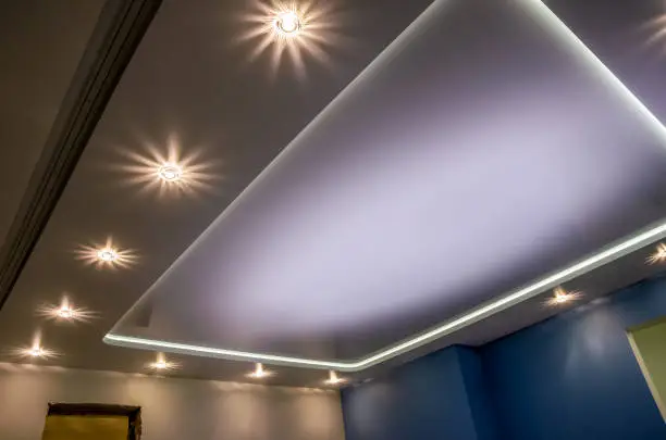 Photo of Beautiful stretch ceiling with led lighting, spotlights around the perimeter.